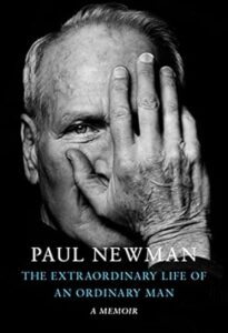 A black and white close-up portrait of a man covering half of his face with his hand, with the text "paul newman - the extraordinary life of an ordinary man: a memoir" overlaying the image.