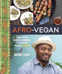 A cheerful chef donned in a white hat is featured on the cover of the "afro-vegan" cookbook, which showcases farm-fresh african, caribbean, and southern flavors remixed by bryant terry. vibrant food plates and bold patterns border the title, inviting a taste of delicious vegan cuisine.