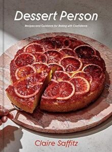 A beautiful, citrus-topped cake takes center stage on the cover of "dessert person" by claire saffitz, tempting readers with the promise of delicious recipes and expert baking guidance.