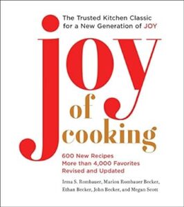 The image shows the cover of a cookbook titled "joy of cooking." it's described as "the trusted kitchen classic for a new generation" and mentions that there are 600 new recipes, with more than 4,000 favorites. the authors listed are irma s. rombauer, marion rombauer becker, ethan becker, john becker, and megan scott. the design is simple, featuring a large, red-letter "j" followed by the words "oy of cooking" in smaller black font against a plain, light background.