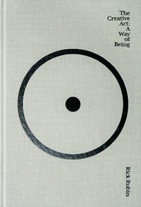 A minimalist book cover with a large, off-center circle and a smaller filled circle in the center, symbolizing focus or an idea, with the title "the creative act: a way of being" by rick rubin.