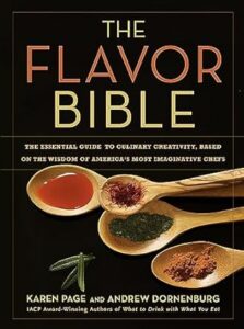 The flavor bible: a culinary guidebook cover featuring wooden spoons with an assortment of spices and herbs, inviting readers to explore the essentials of cooking creativity.