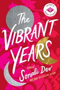 A novel titled "the vibrant years" by sonali dev, presented as a pick from mindy's book studio, with accolades as a usa today bestselling author. the cover features a bold, pink background with floral patterns, accented by a silver crescent moon and a scattering of golden stars.