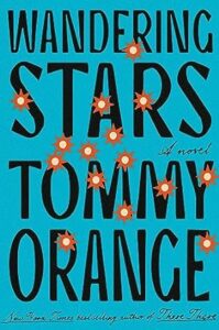 Wandering stars" - a vivid blue book cover featuring the title and author's name, tommy orange, decorated with a pattern of orange stars and red bursts, evoking a sense of movement against the static background.