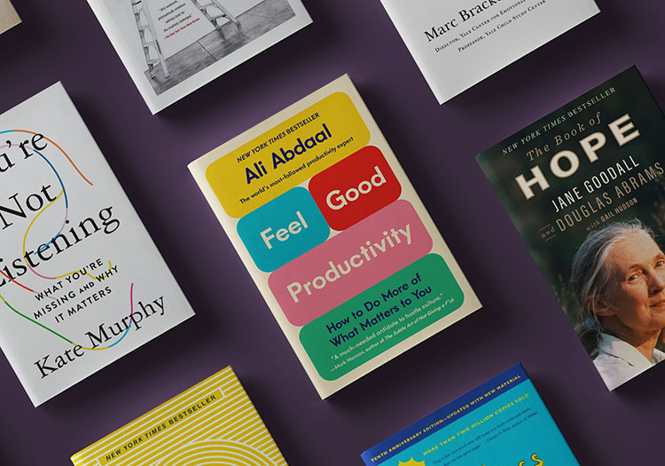 A diverse collection of books spread out on a purple surface, each featuring different titles and cover designs that suggest a focus on personal development, productivity, and self-improvement.