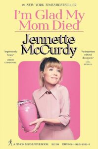 A woman holding a pink urn gives a coy smile against a yellow background with text that reads "i'm glad my mom died" by jennette mccurdy, stating it's a #1 new york times bestseller and includes pricing and isbn information.