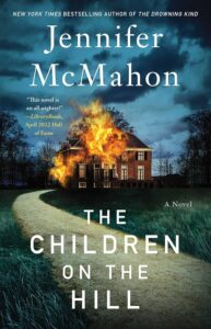 A book cover for "the children on the hill" by jennifer mcmahon, featuring a fiery silhouette of a house against a dark sky with an ominous path leading up to it.