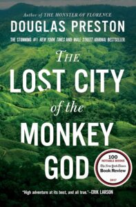 A lush green mountainous landscape with an overlay of a book cover titled "the lost city of the monkey god" by douglas preston, acclaimed by the new york times and wall street journal, with a notable book endorsement from erik larson highlighting the book's high adventure.