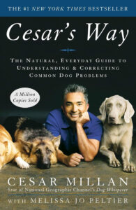 Book cover of "cesar's way" by melissa jo peltier featuring cesar millan smiling with a german shepherd and a labrador retriever, highlighting it as a new york times bestseller.