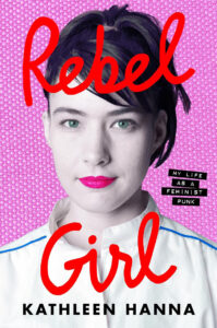 Book cover of "rebel girl" by kathleen hanna featuring a close-up portrait of a woman with short, dark hair against a bright pink background, with title and author's name in bold white letters.