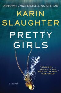 A locket submerging in water, creating ripples around it, on the cover of karin slaughter's thriller novel "pretty girls.