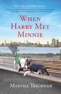 Book cover of "when harry met minnie" by martha teichner. features a white bull terrier and a black dog wearing a green outfit, with new york city skyline in the background.