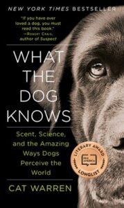 Book cover of "what the dog knows" featuring a close-up of a dog’s face, predominantly the eyes, with the title and author's name, cat warren, displayed on top.