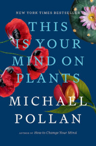 The cover of the book "This Is Your Mind on Plants" by Michael Pollan. The background is dark blue with large images of flowers, including red poppies and a pink flower with a green stem. The author is noted as the writer of "How to Change Your Mind.