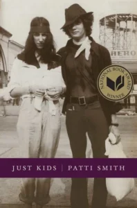 Vintage photo of two people in casual attire, one with a hat. "Just Kids" book cover by Patti Smith.