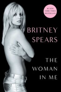 Black and white cover of "The Woman in Me" with a woman posing and covering her chest.