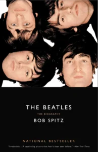Book cover for "The Beatles: The Biography" by Bob Spitz, featuring four faces on a black background.