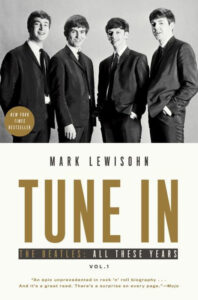 Black and white photo of four men in suits. Book title: "Tune In: The Beatles: All These Years Vol. 1" by Mark Lewisohn.