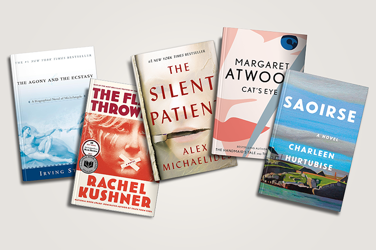 Five books standing upright, including titles by Irving Stone, Rachel Kushner, Alex Michaelides, Atwood, and Hurtubise.
