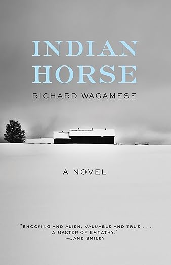 Book cover of "Indian Horse" by Richard Wagamese shows a snowy landscape with a building and tree in the distance.