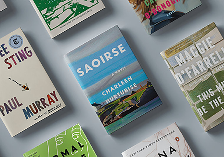 Several colorful books are arranged on a flat gray surface, viewed from above.