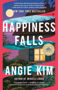 Book cover of "Happiness Falls" by Angie Kim, featuring a house, trees, and colorful sky with book award stickers.
