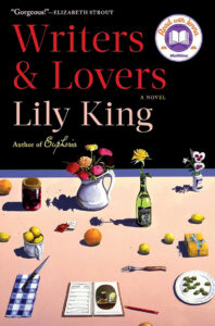 A table with flowers, fruit, wine, and books on it; "Writers & Lovers" by Lily King written above.