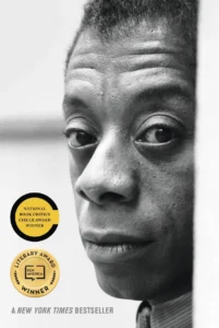 Black and white close-up of a man’s face with two literary award badges and text: “A New York Times Bestseller.”.