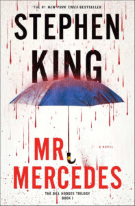 Book cover of “Mr. Mercedes” by Stephen King, featuring a blue umbrella with red blood-like splatters.
