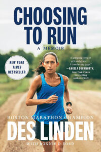A woman in a blue tank top runs on a dirt path; text reads “Choosing to Run” by Des Linden.
