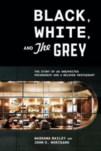 Book cover for “Black, White, and The Grey” with a restaurant scene visible through a window.