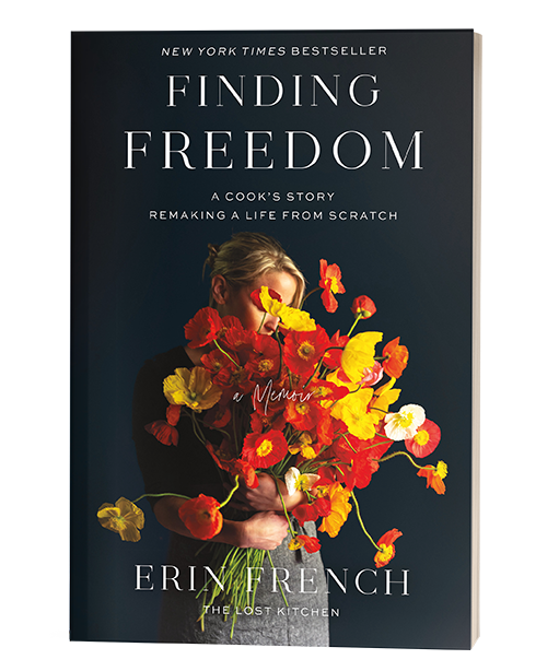 A woman holds a large bouquet of colorful flowers on the cover of the book “Finding Freedom” by Erin French.